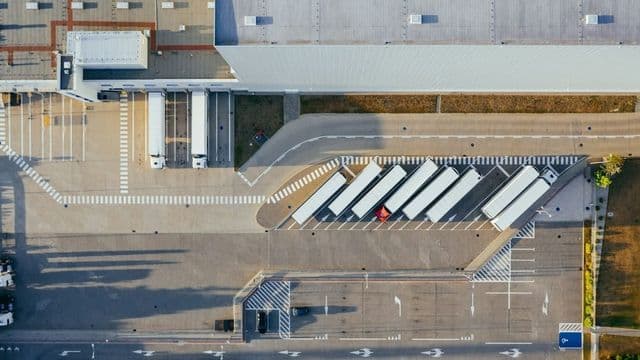 Vista aérea de centro de distribuição com carretas encostadas nas docas de carga ao entardecer