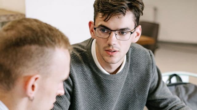 Dois profissionais de marketing conversando sobre anotações e planejamento de campanha