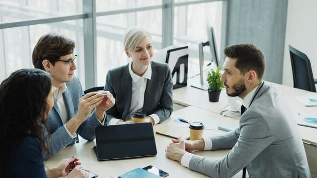 Equipe de profissionais de compliance em reuniao de governanca corporativa