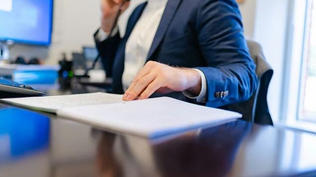 Contador analisando documentos financeiros em investigação de fraude, contabilidade forense