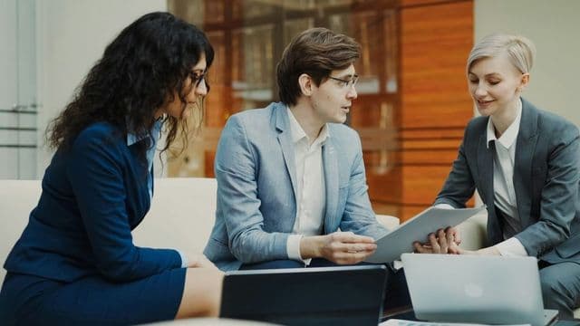 Advogados analisando documentos financeiros em escritório, tema Direito Econômico e Financeiro