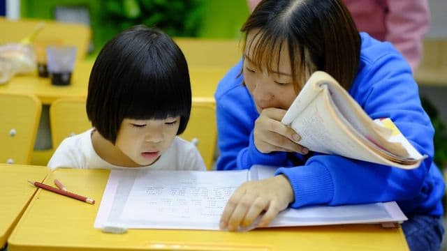 Professora acompanhando aluna em atendimento individualizado, essência da educação especial e inclusiva