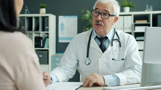 profissional de saude conversando com paciente em consultorio, representando a equipe multiprofissional de nefrologia