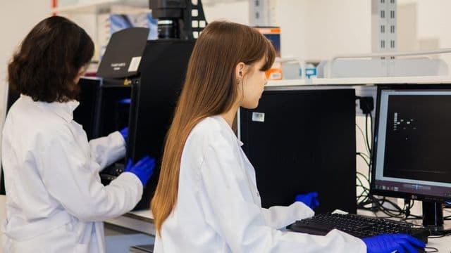 Peritas criminais analisando amostra de DNA em laboratório de perícia