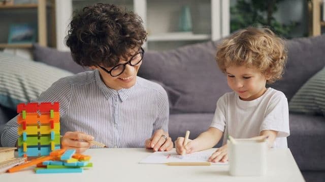 Psicóloga faz avaliação lúdica com criança em consultório, cena da psicologia jurídica aplicada a casos de alienação parental