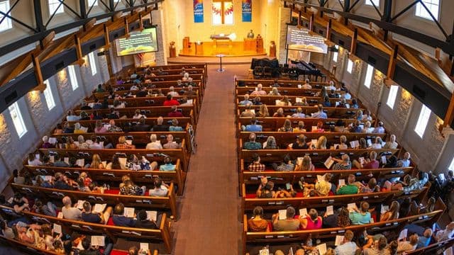 Interior de igreja cheia durante culto, ilustrando o crescimento da Teologia Religiosa no Brasil