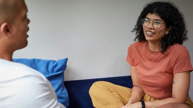 Casal em conversa aberta e acolhedora, representando a terapia de casal e familia