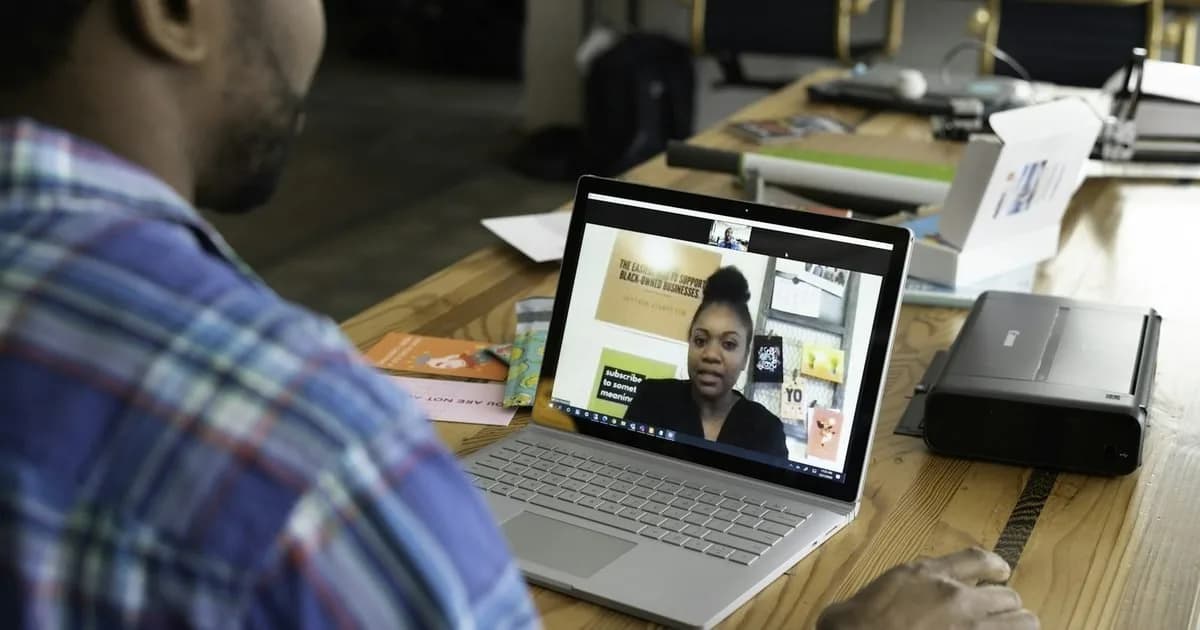 Estudante em videochamada com tutora EAD que conduz a aula na tela do notebook